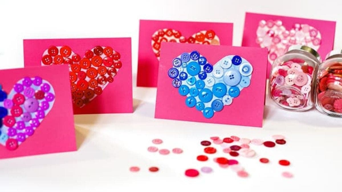 Love letters embellished with buttons in heart shape are placed on a white background. 