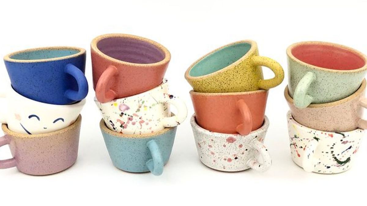 Multiple ceramic mugs are placed on a white background. These ceramic mugs are in multiple colors.