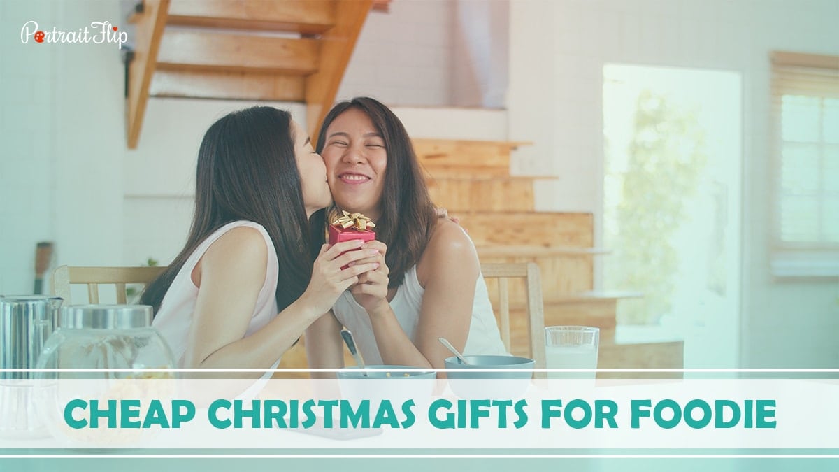 Cheap Christmas Gifts For Foodie: A girl is kissing her best friend by giving her Christmas gifts.