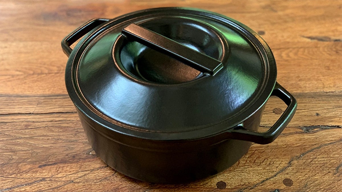 a black Dutch oven on a brown table