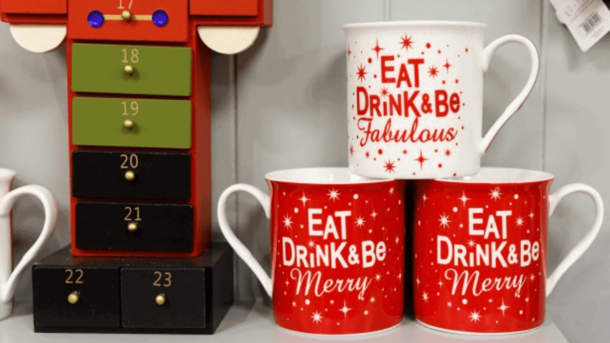 Three Christmas mugs that have "Christmas Quotes" written on their sides are placed on white surface.  