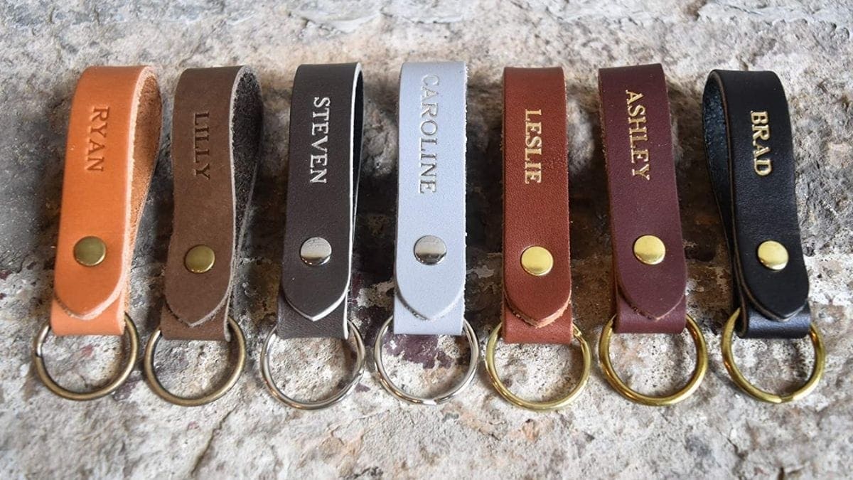 Multi-colored leather keychains are placed on a hard surface. 