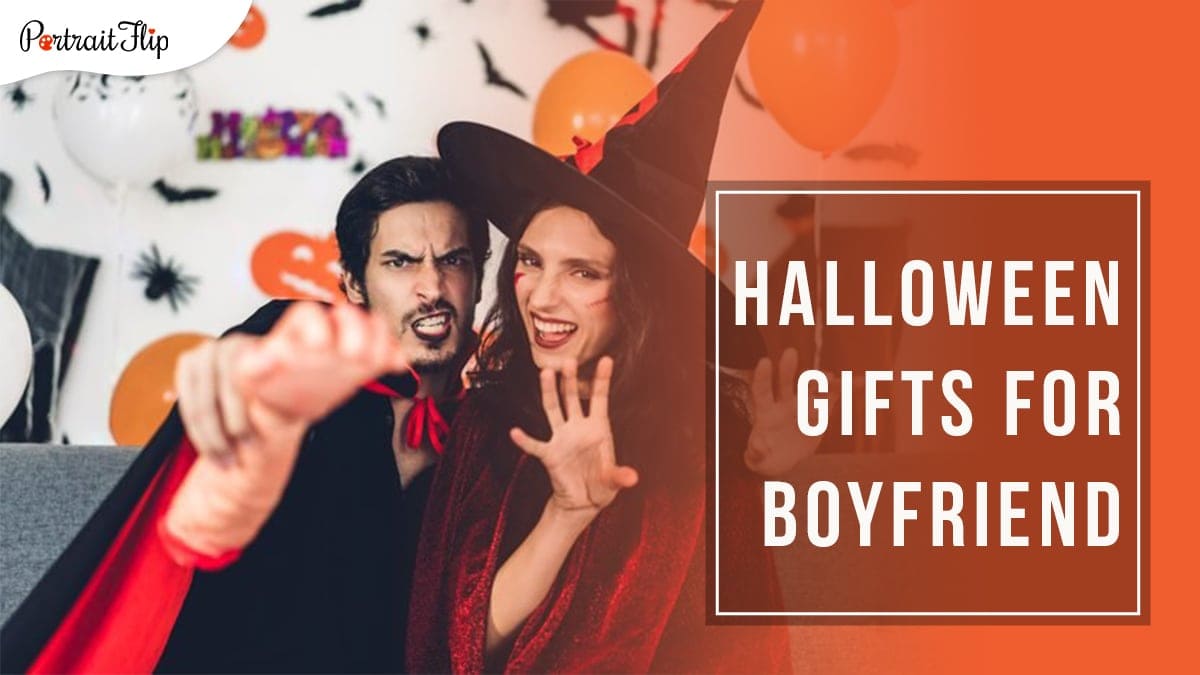 A couple in a vampire and witch outfit sitting on a grey couch with Halloween themed wall décor in the background. the guy on the left is holding a fake human hand and the girl is holding both her hands in a scare position. Halloween gifts for boyfriend is written in a block on the right hand side.