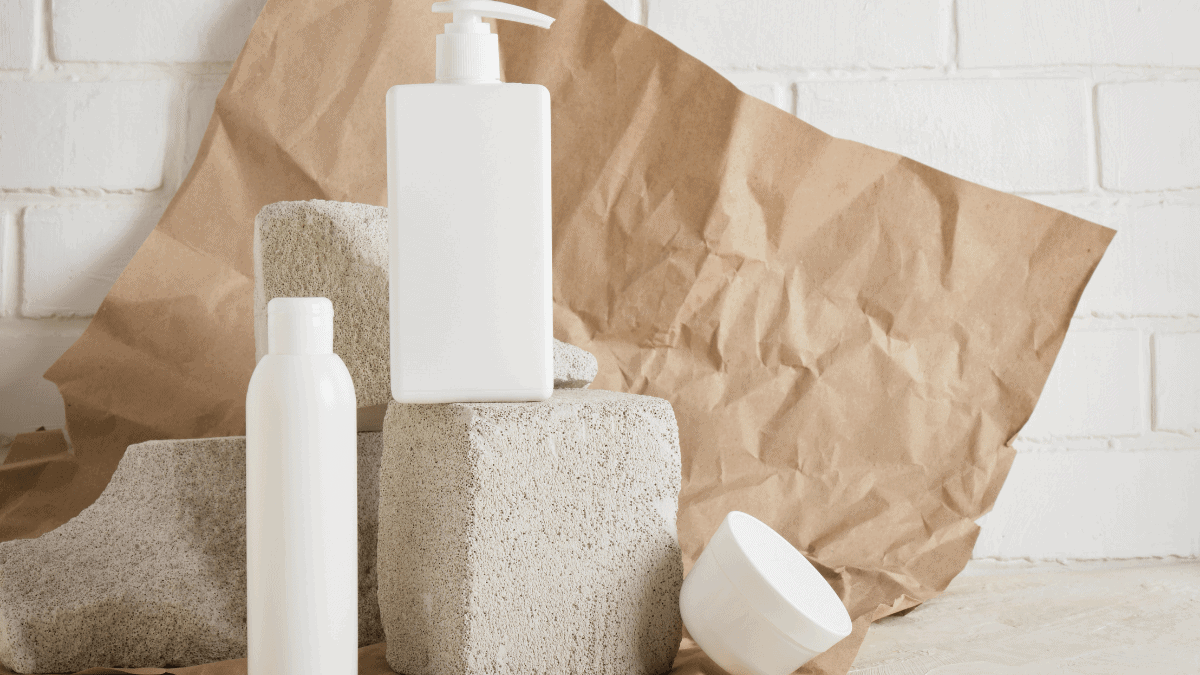 Skincare products are placed on white bricks. There is a brow background and some paper around them.