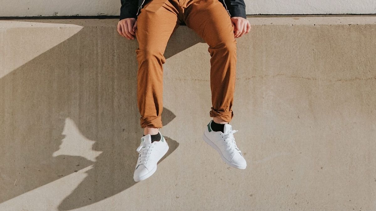A guy flaunting his white sneakers. 