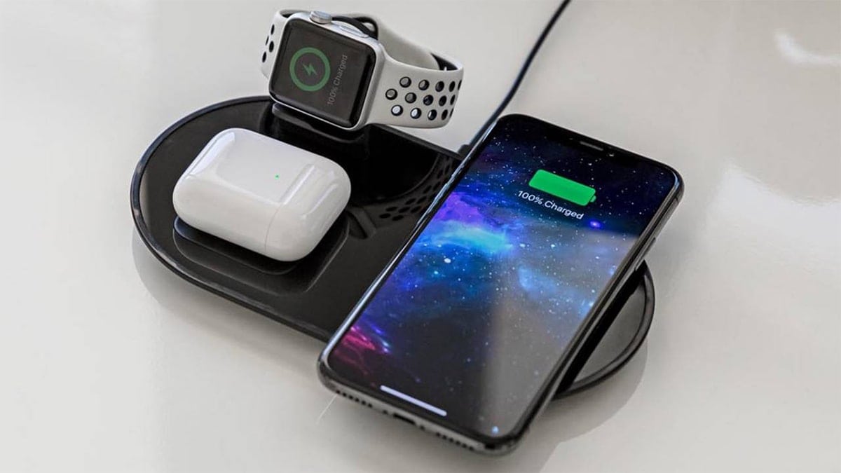 a phone, smartwatch, and wireless airbuds charging on a charging station. 
