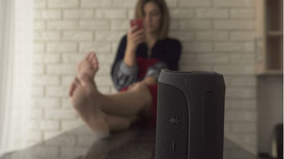 a woman enjoying music with a wireless speaker