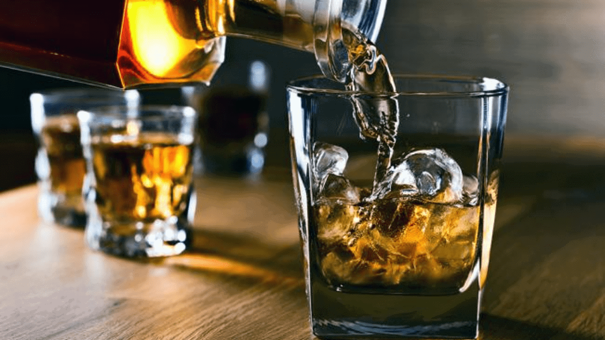 the image depicts whiskey being poured in to a glass filled with ice. 
A bottle of whiskey is one of the best  Christmas gifts ideas for grandpa. 