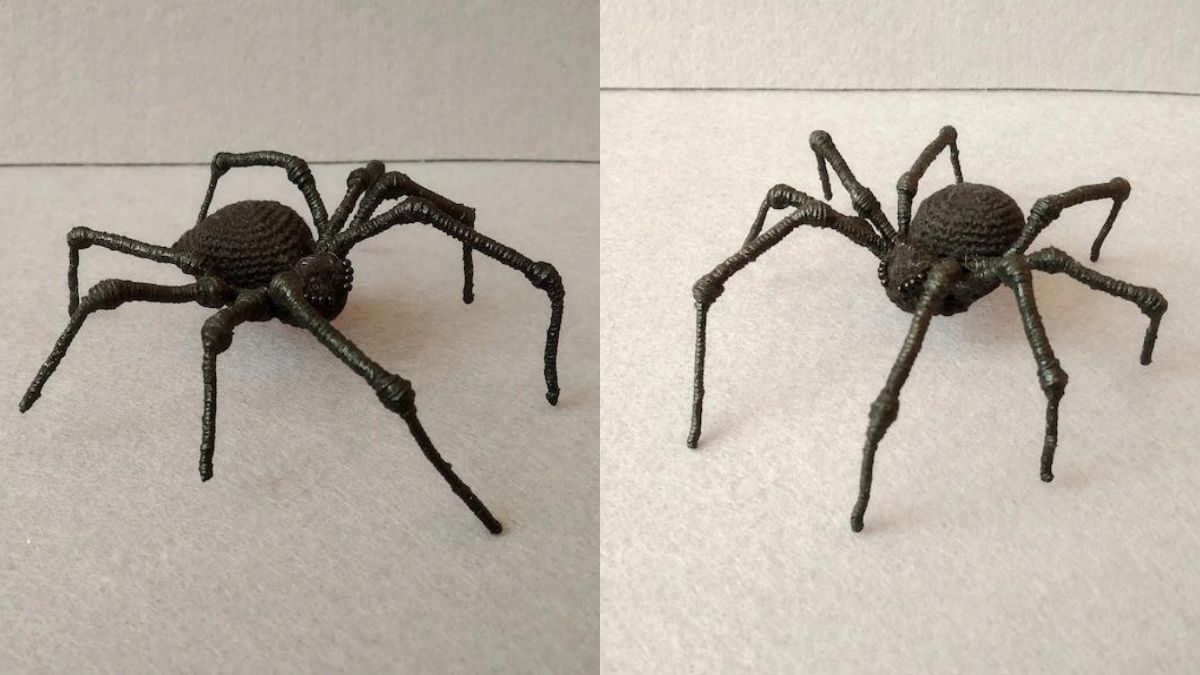 a black crochet spider displayed on a table with a white background