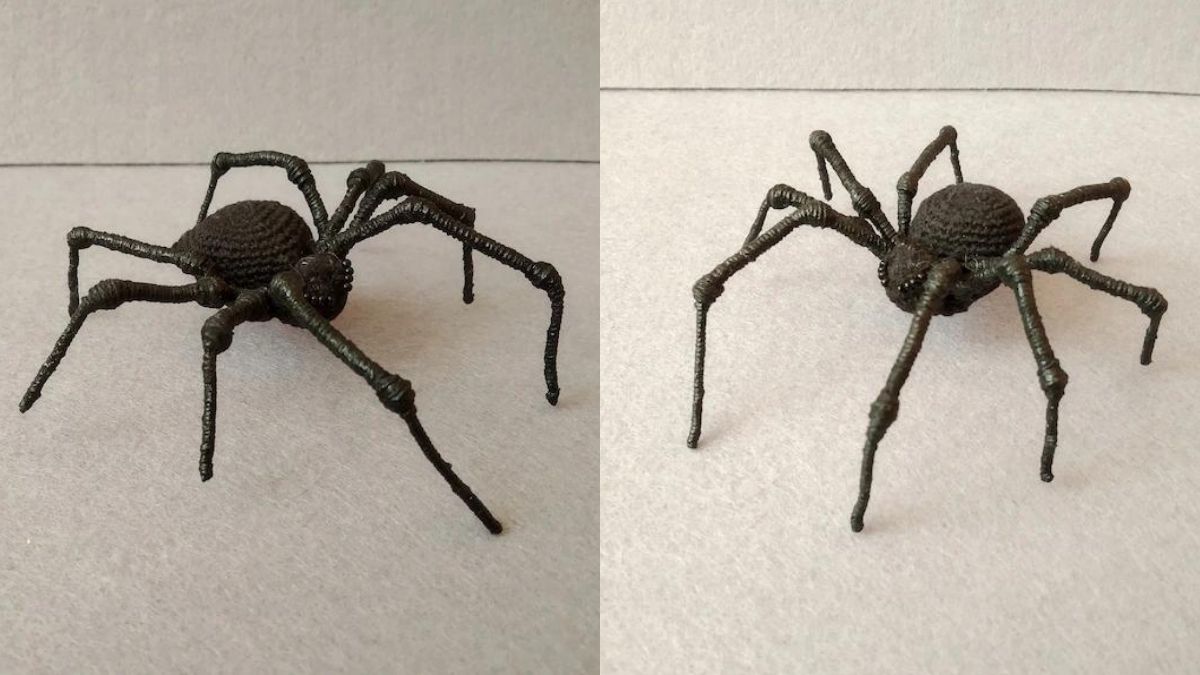 a black crochet spider displayed on a table with a white background 