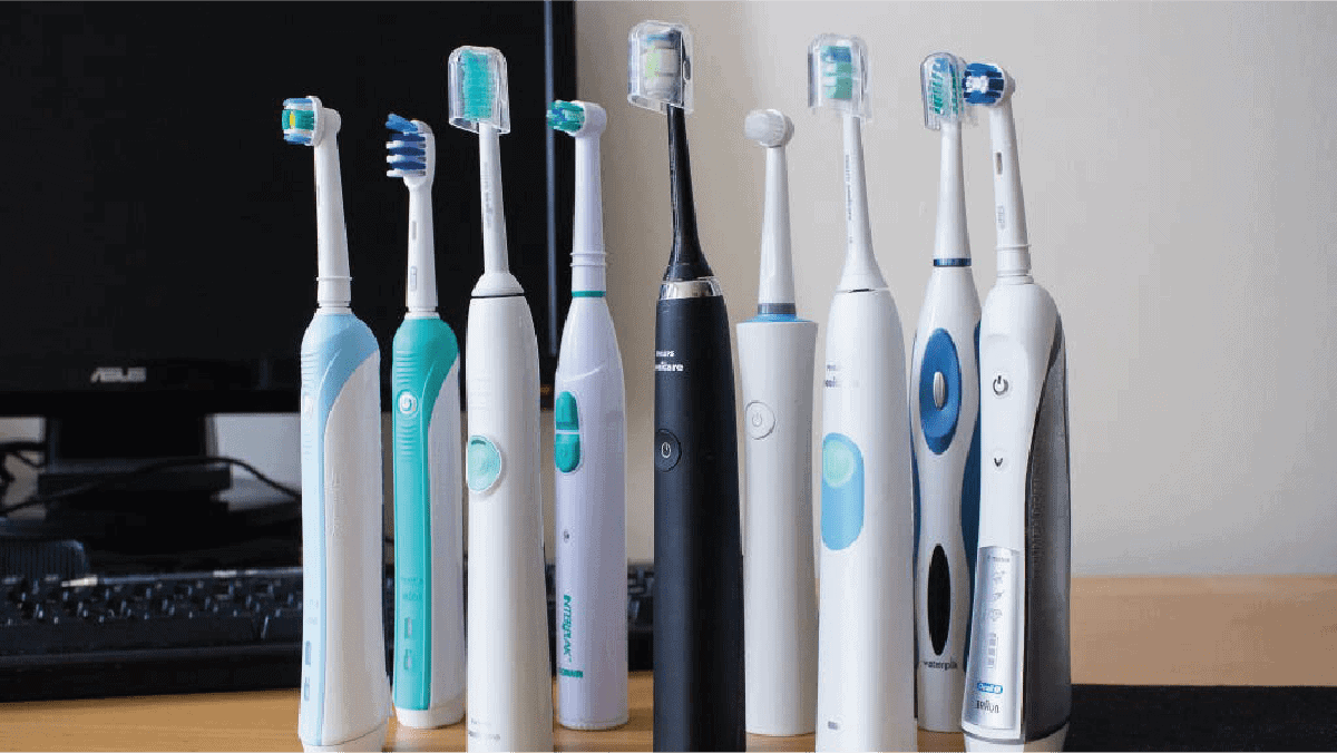9 different Electric toothbrushes kept near a compute screen