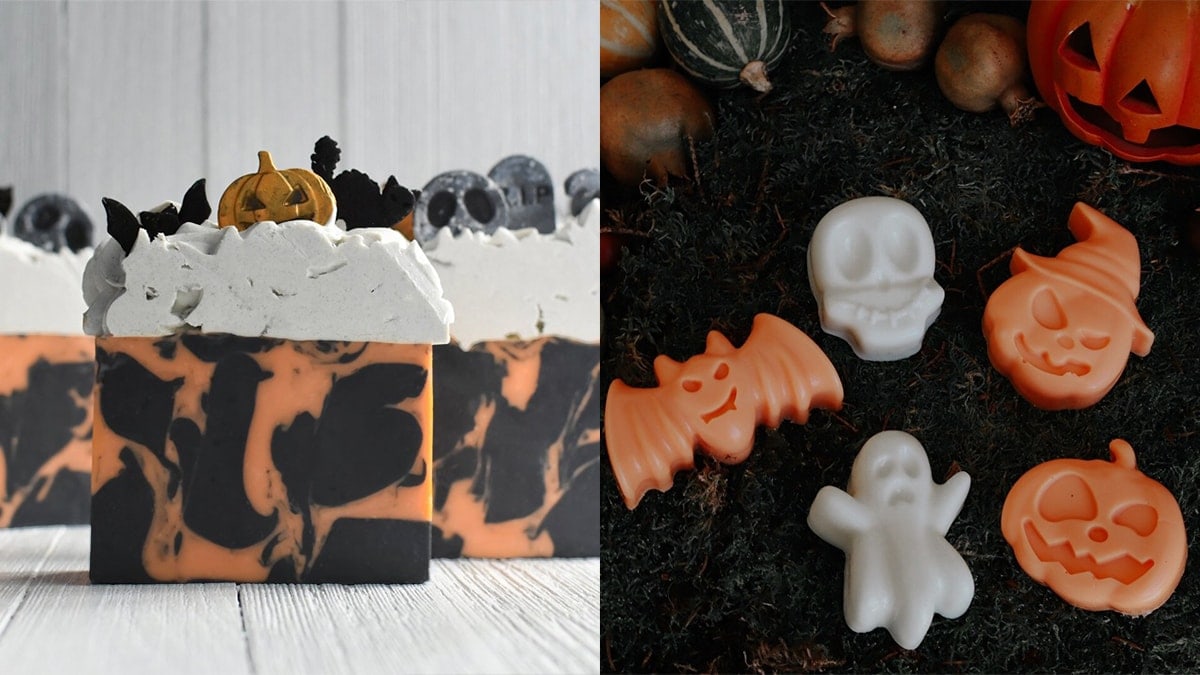 A graveyard themed soap with pumpkin, bat, and a cat as a topper on the left. Right and white colored soaps in the shapes of bat, ghost, skull and Jack-o-Lantern displayed on the ground.