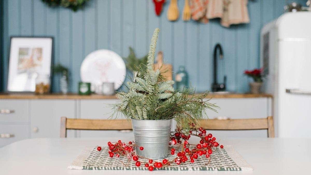 A beautiful yet small Christmas vase is placed on the white table in the pantry. 