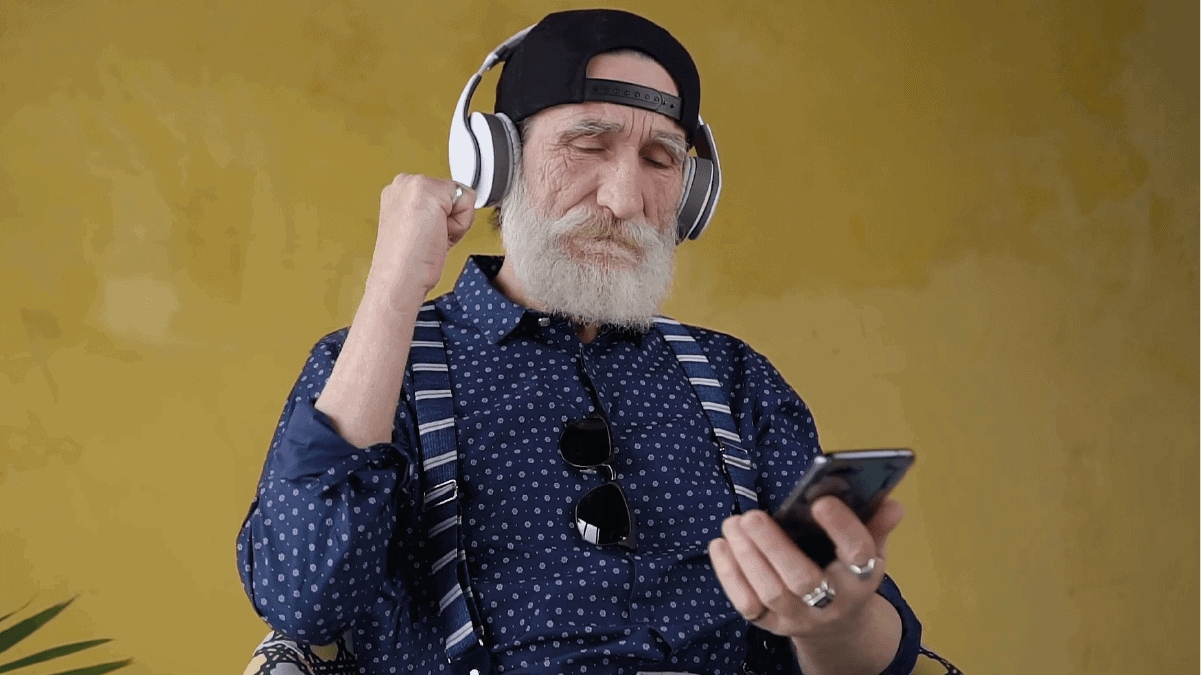 an elderly man enjoying music on noise-canceling headphone. 