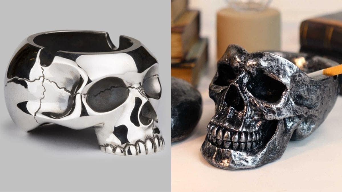 Oxidized and Silver colored ashtrays in the shapes of skulls with a stubbed cigarette in the oxidized skull ashtray as a Halloween present.