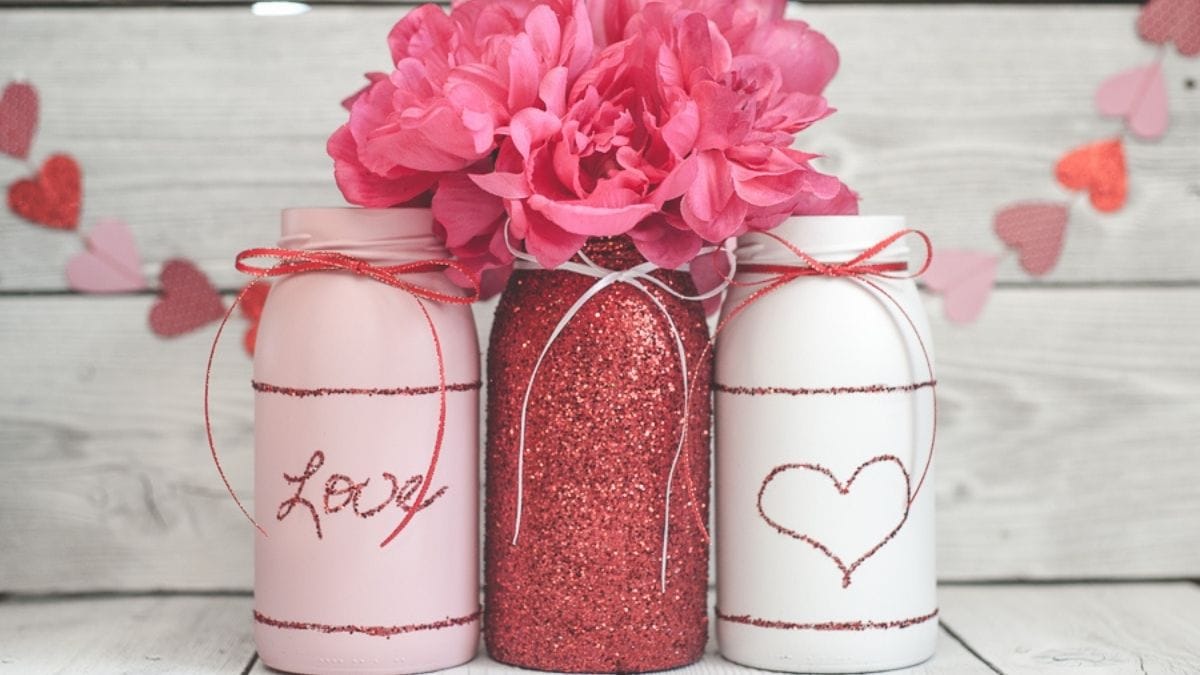 3 mason jars are decorated with glitters and flowers for valentine's day 