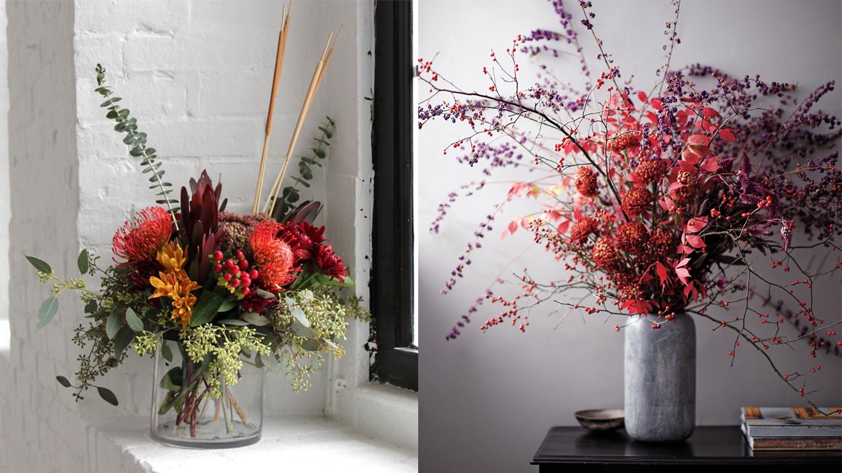 on the left:  a branched floral is placed in a glass jar at window side. On the right: a red -purple  branched floral in a vase is placed on a brown table. 