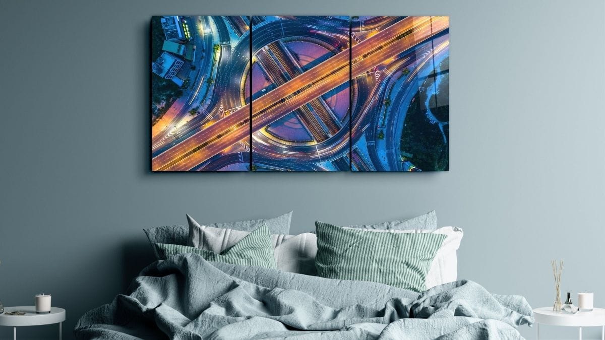 a bedroom wall with a one in three painting.