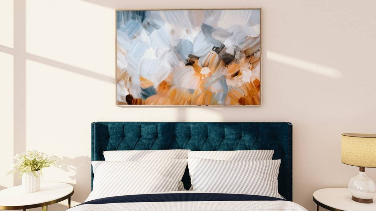 A bedroom wall with an abstract painting.