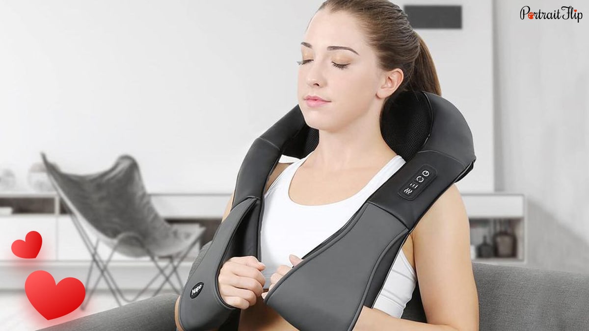 A woman using neck and shoulder massager. 