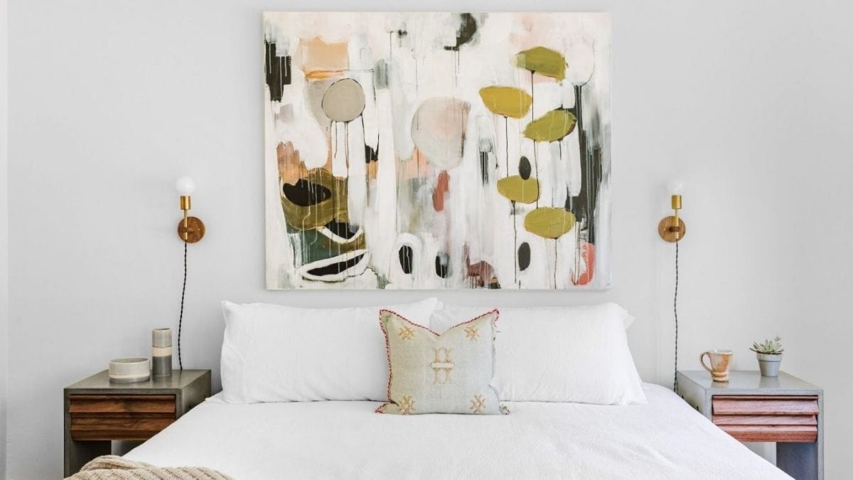 a beautiful abstract tapestry draped above a bed.