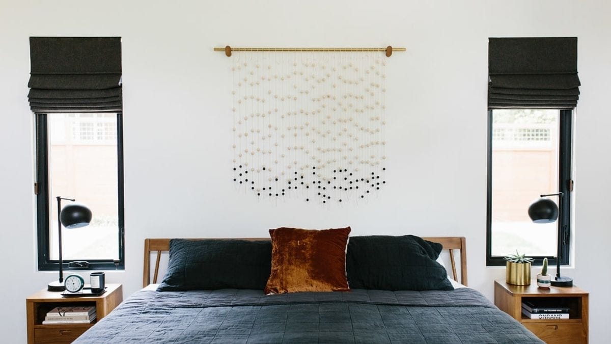 a black and white macramé displayed on a bedroom wall as a wall décor.