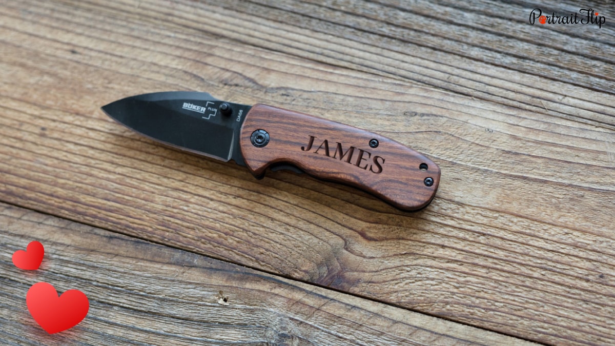 A brown pocket knife with black blade, and has "James"  engraved on the handle. 
