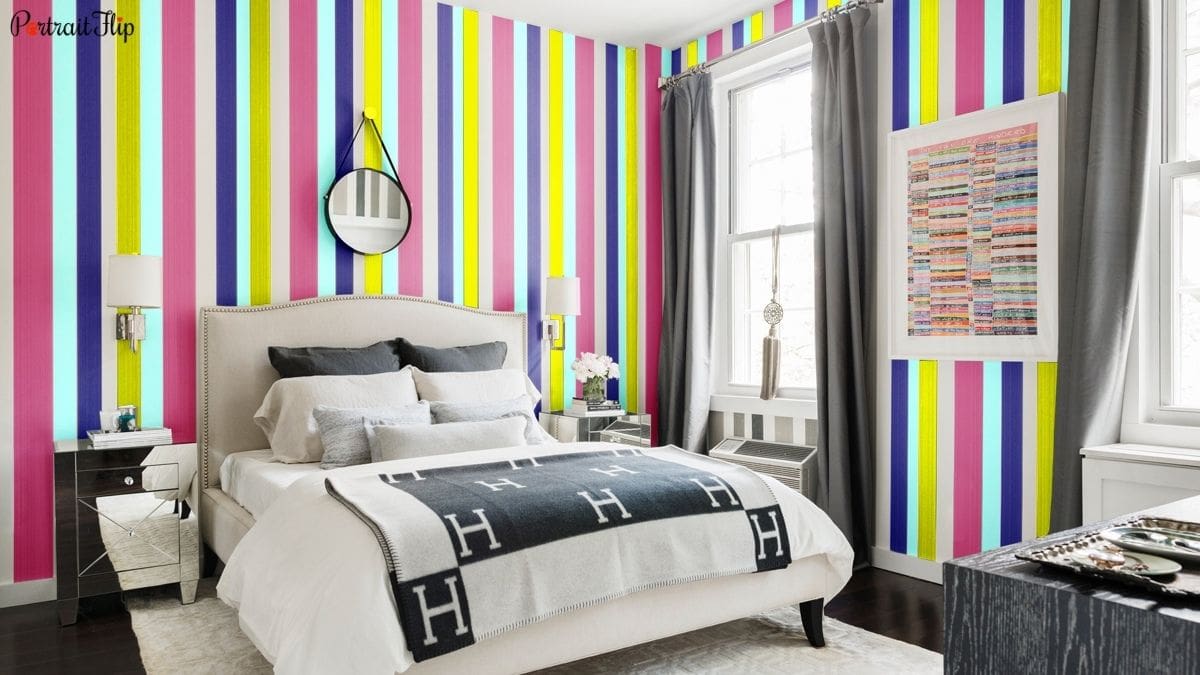 a women's wall painted in colorful stripes that represent positive energies as a bedroom wall decor idea.