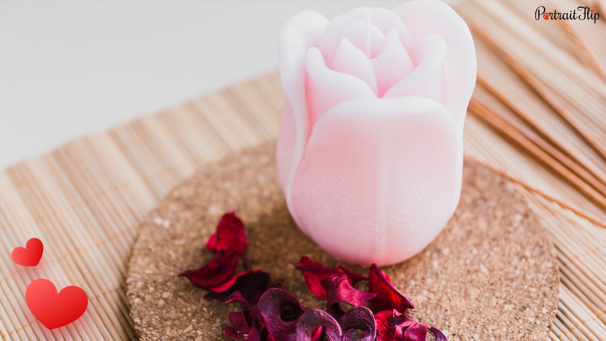 A Pink colored handmade rose candle that resembles a small rose. 