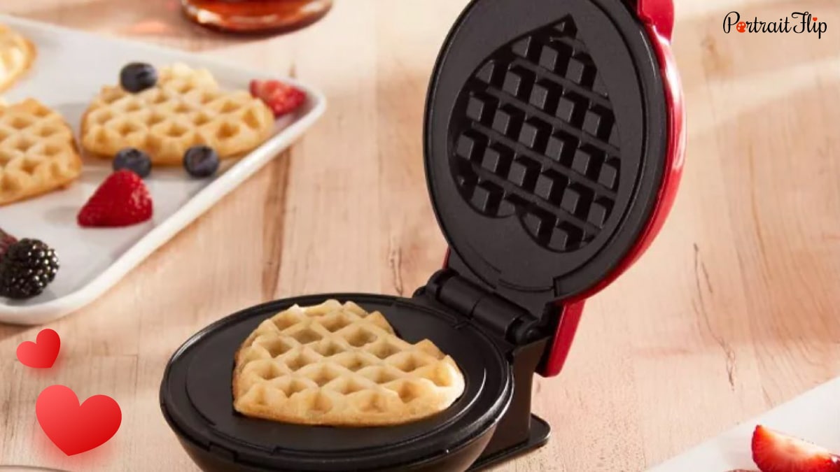 Heart-shaped mini waffle maker kept on a brown table