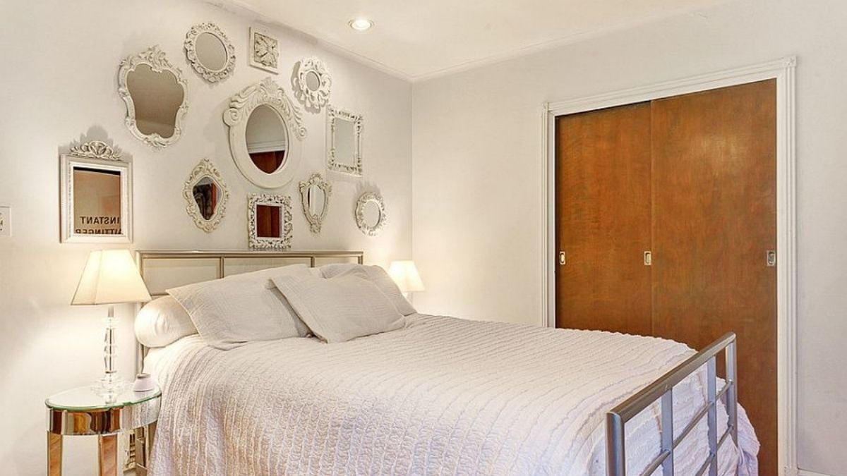 multiple engraved mirrors propped on a bedroom wall making it look spacious and unique.