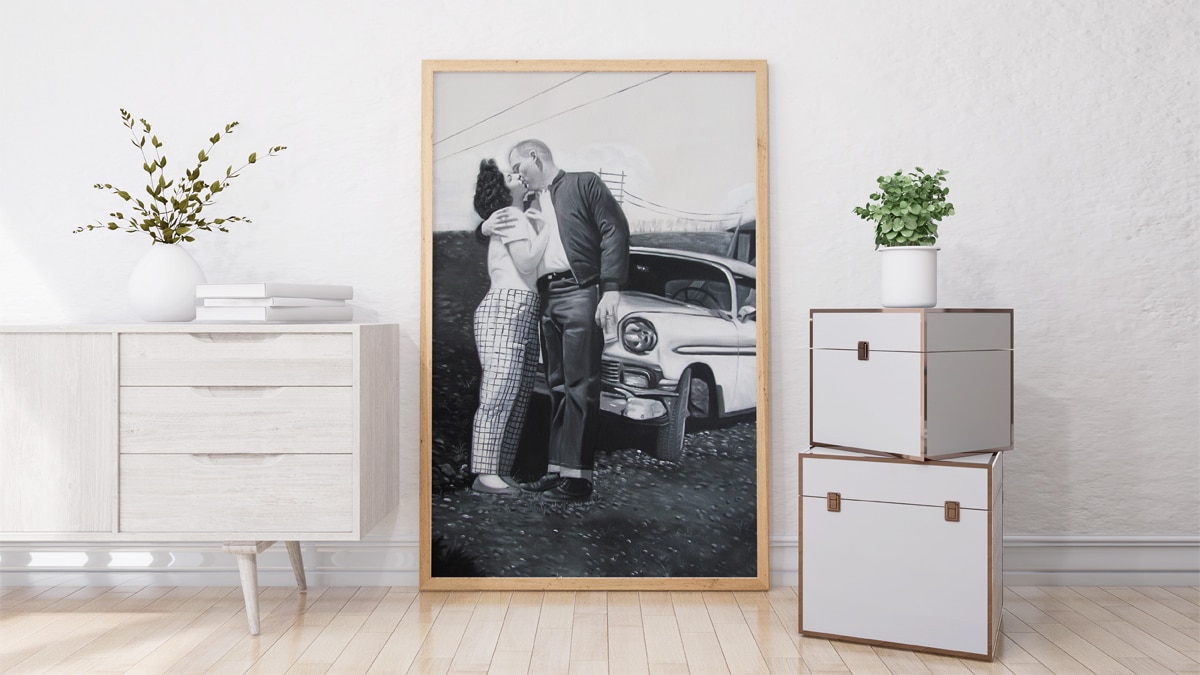 A beautiful interior wall decorated with one of PortraitFlip's customer's kiss portrait of a vintage couple shown kissing in front of a car.