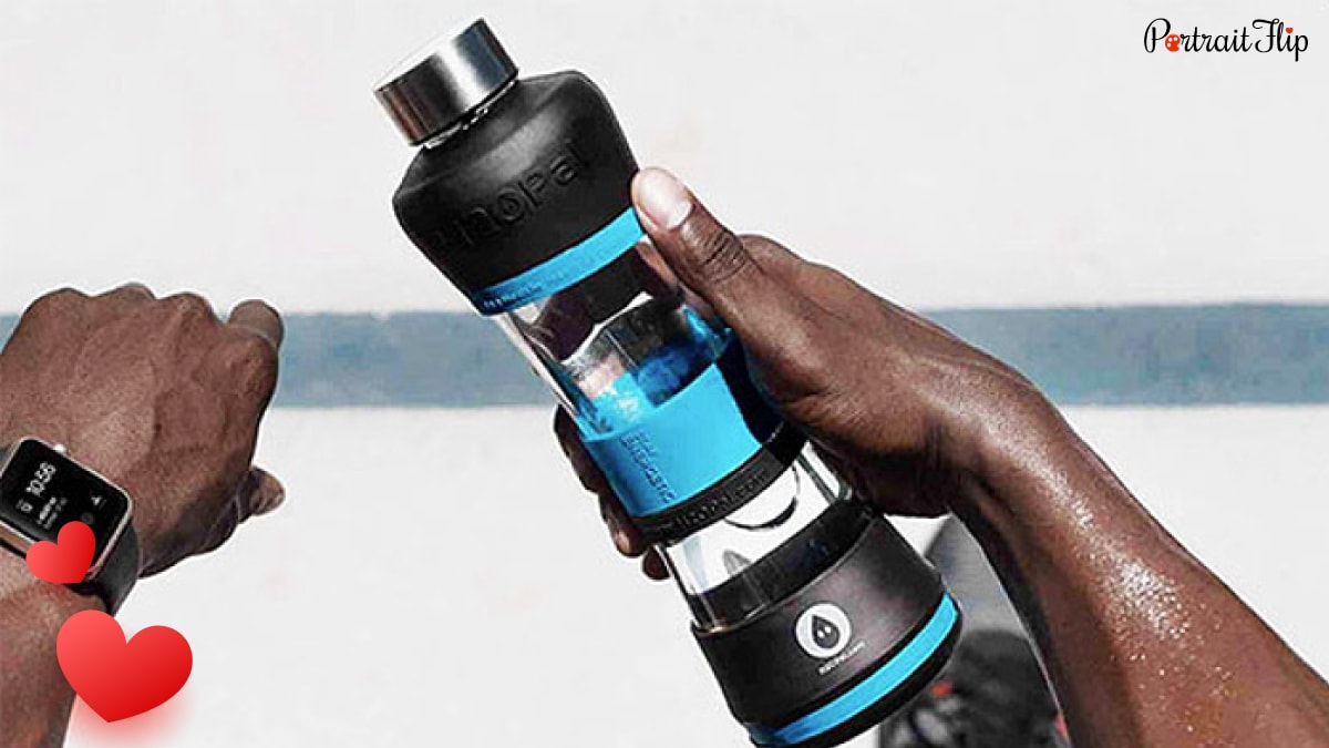 A man holding a blue-black smart water bottle