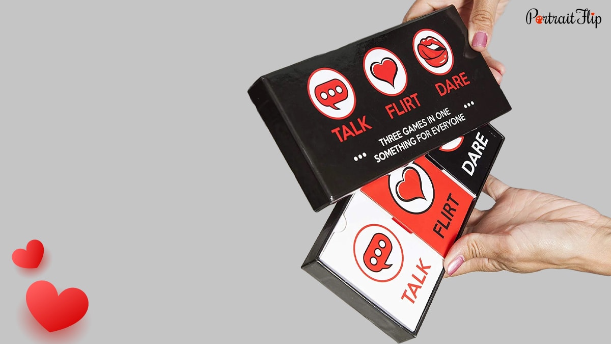 A hand removing Talk, Flirt, Dare game cards