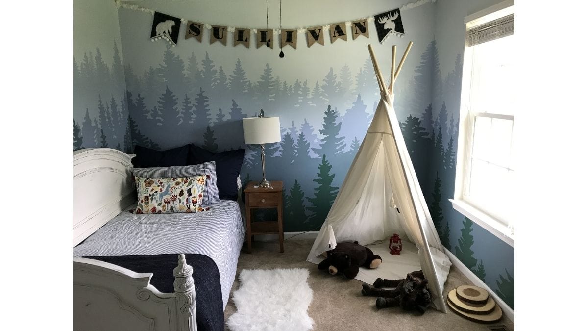 a boy's bedroom wall painted with mountains which is an excellent bedroom wall decor idea.
