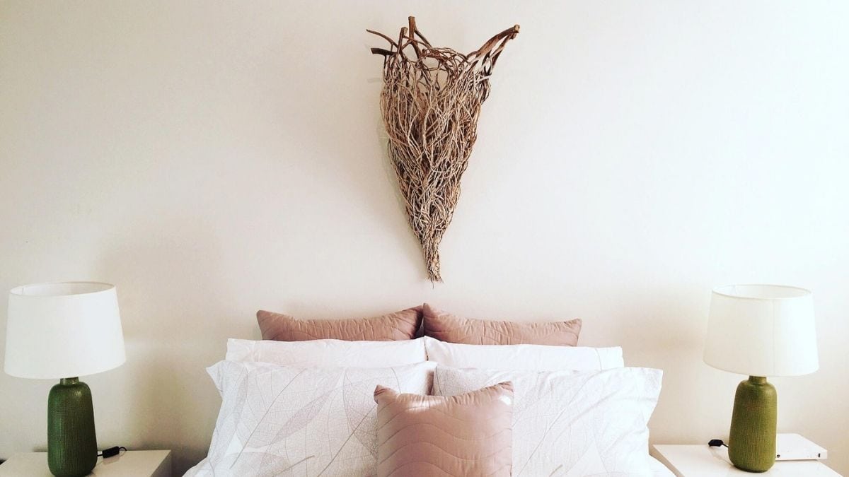 a beautiful natural sculpture hung above a bed as a wall décor.