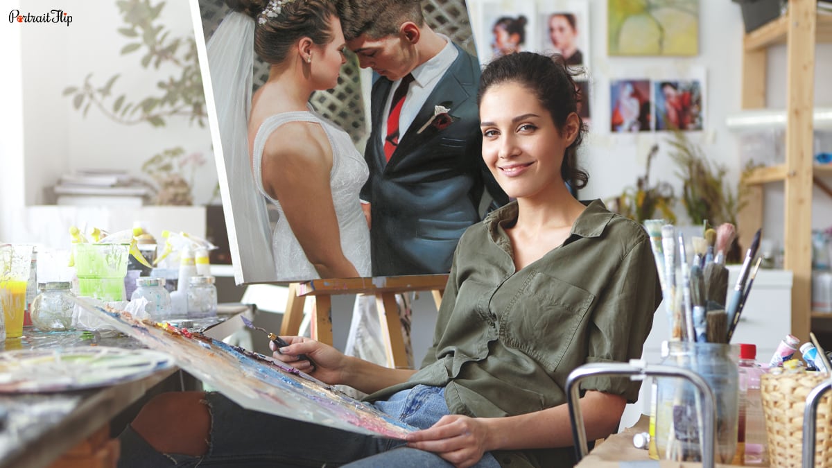 an artist looking at camera in her studio. Behind her is a wedding painting made by the artists of portraitflip