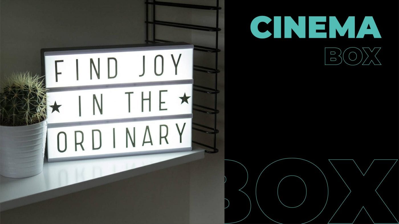 a lit cinema box that reads " Find Joy In The Ordinary"