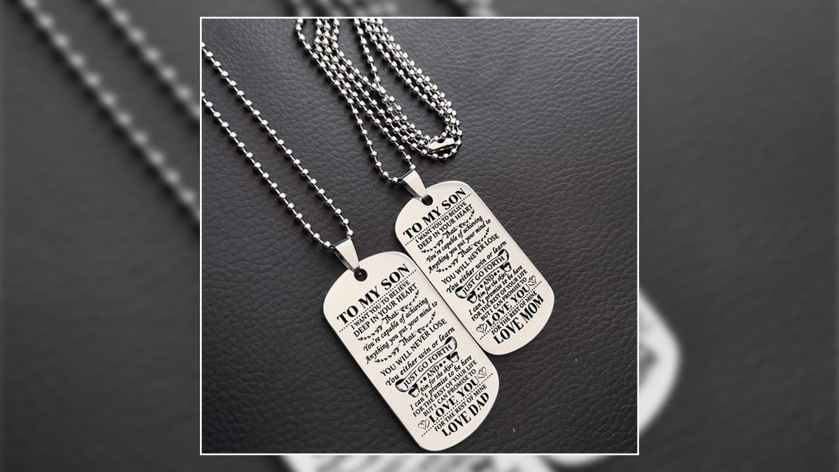 There are dog tags that are sitting on a leather background and they are one of the graduation gift ideas for son.