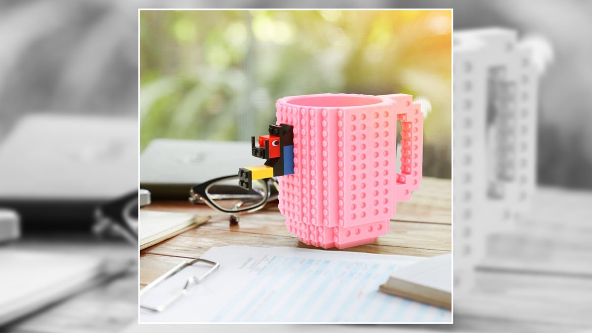 a pink lego mug  kept on a table. 