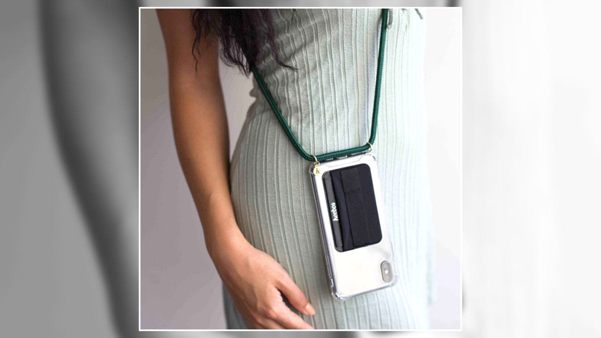 a woman wearing a phone strap with her cellphone attached to it. 