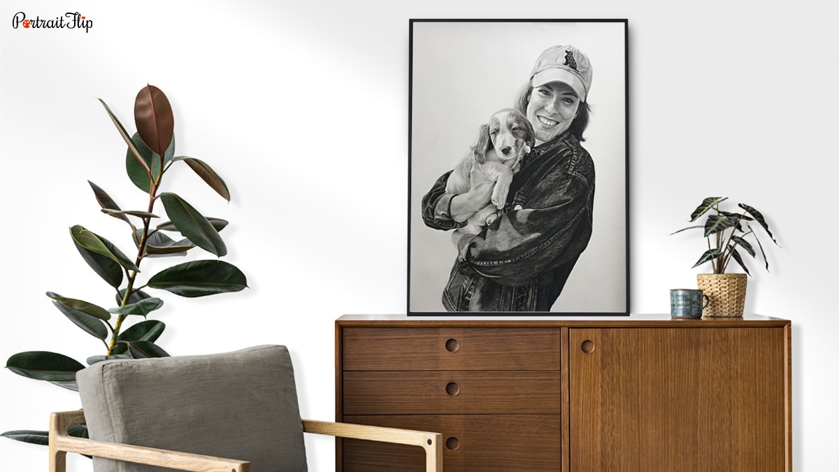 A charcoal handmade custom painting of a person with her pet, surrounded by plants and a chair.