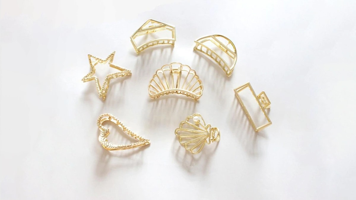 Beautiful golden claw clips kept on a white background. 