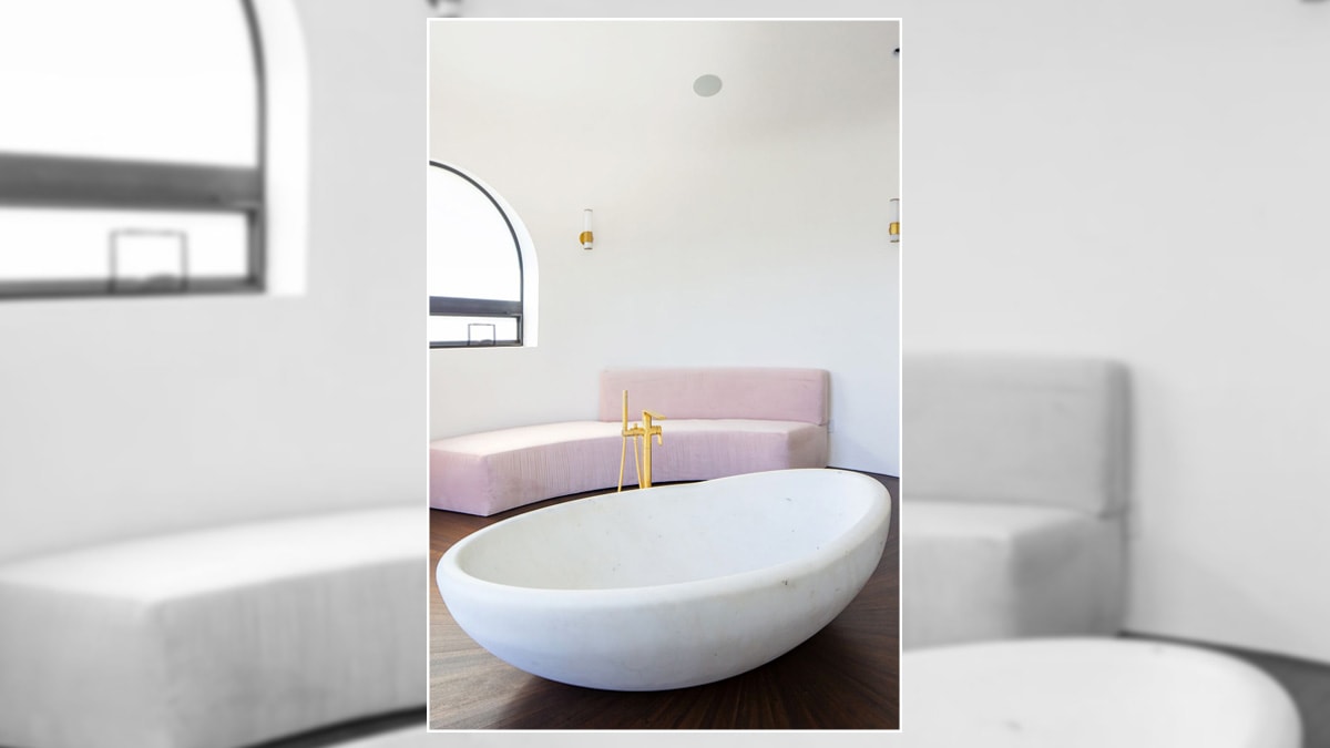 Modern bathroom decoration with a bathtub and semi-rounded windows.