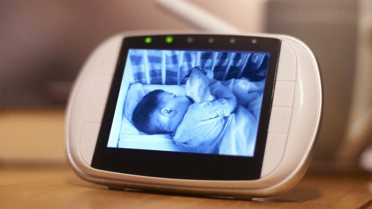  a baby monitor with a video of baby sleeping in crib playing. 