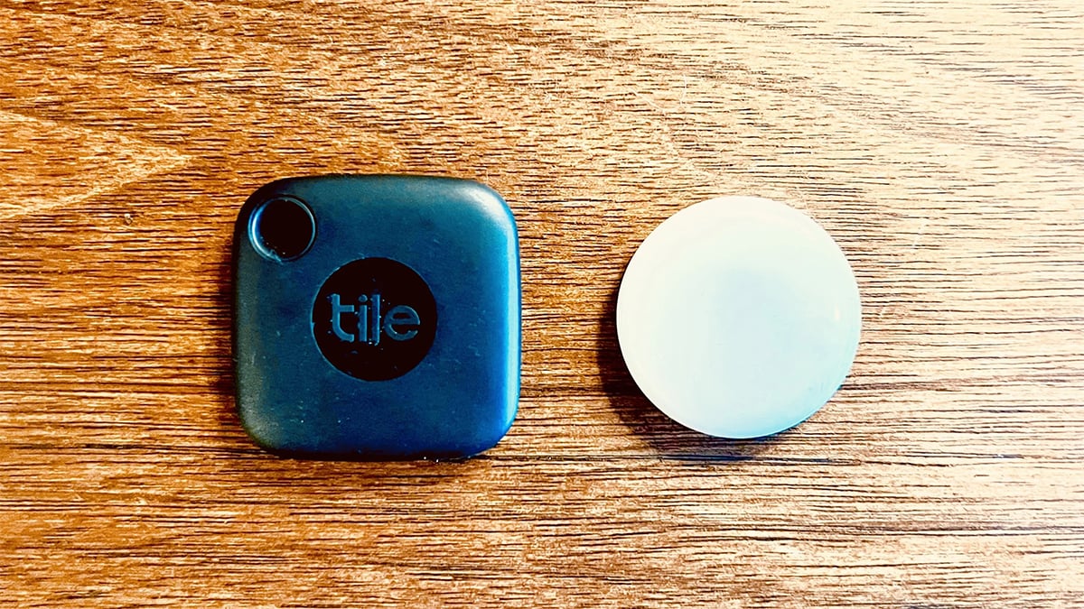 Bluetooth trackers : a blue Tile tag and white round one. tracker; kept on a table. 