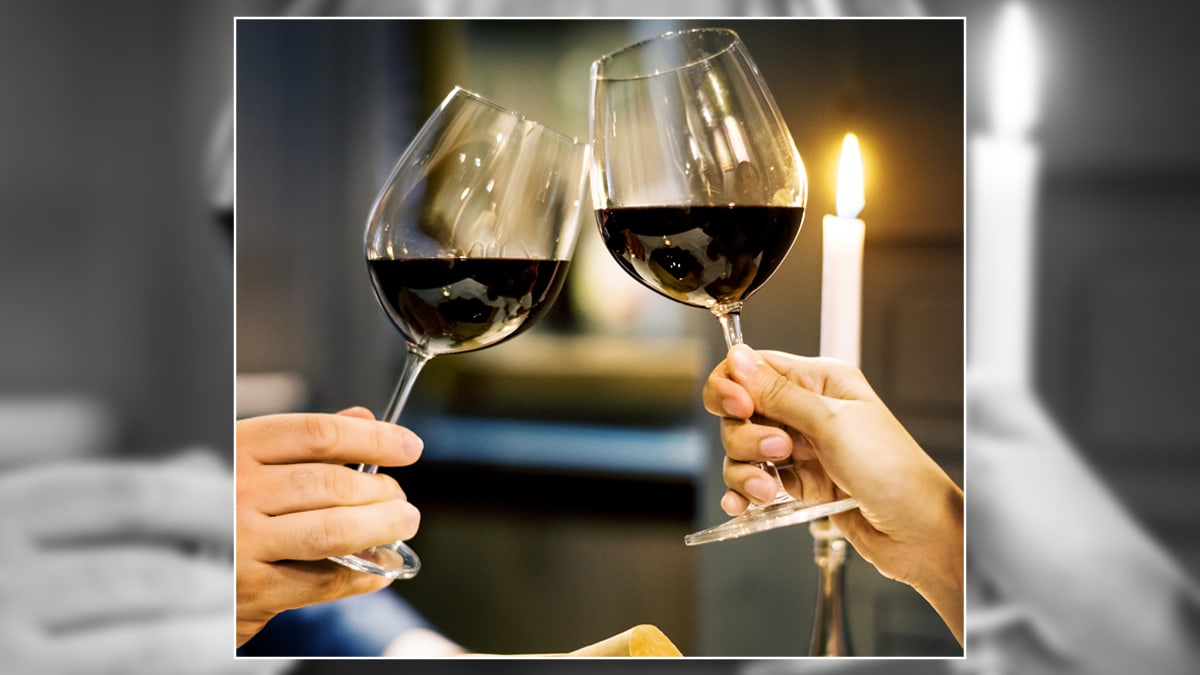 Two people raising their wine classes for anniversary