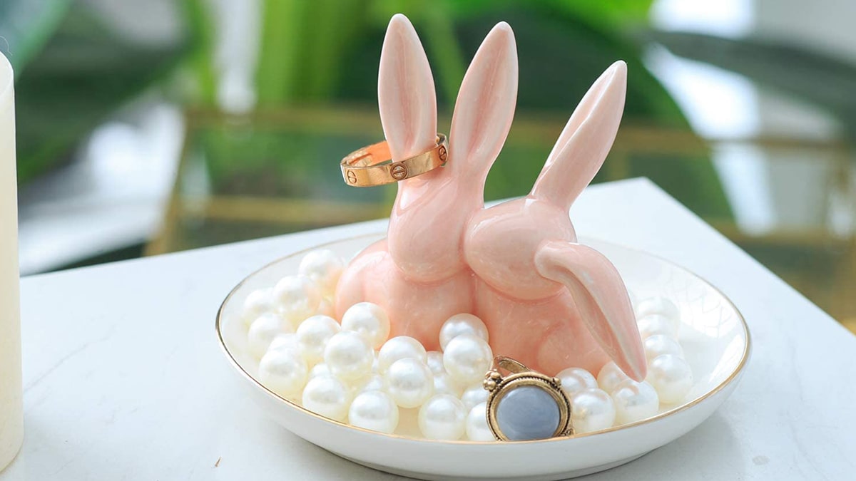 Two cute bunny ring holder. they are placed in a bowl with pearls. A gift for a bunny lover.
