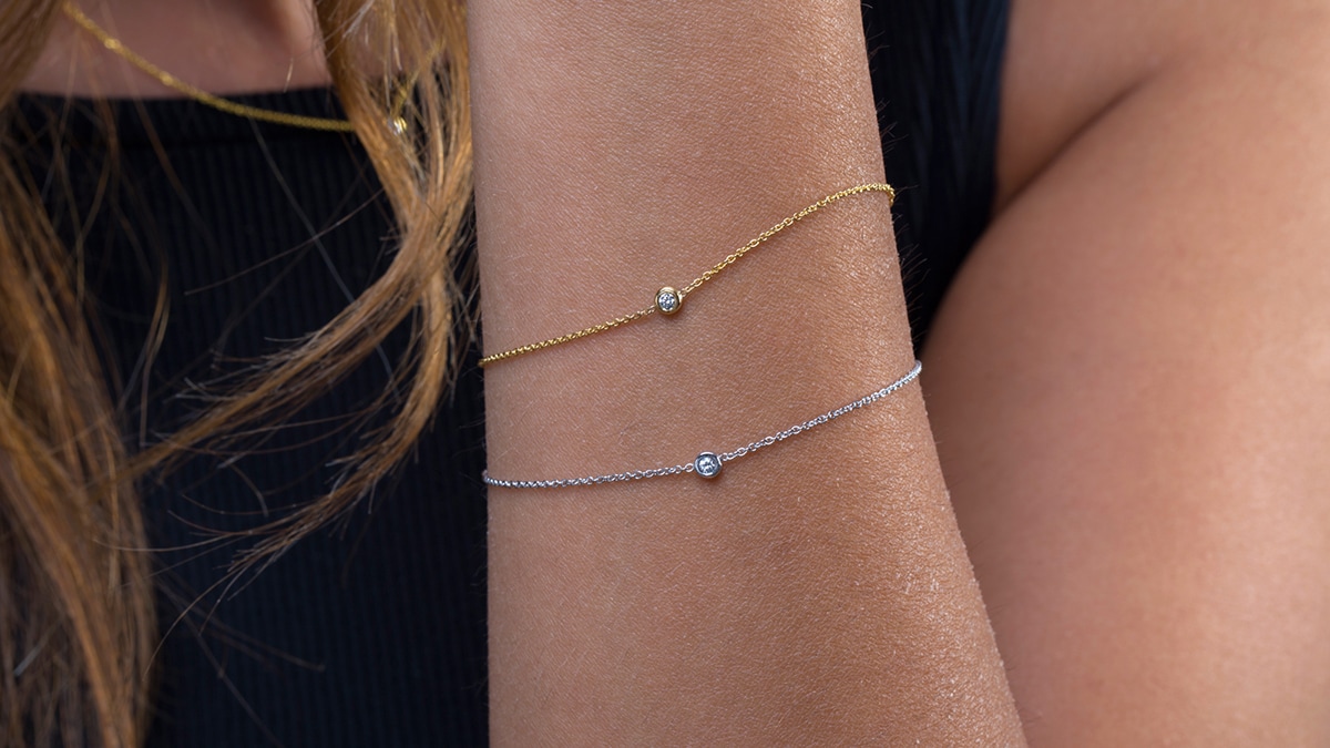 A woman wearing silver and gold Dainty bracelet. 