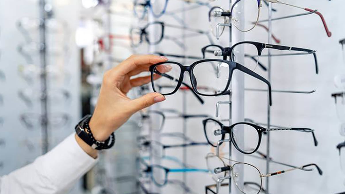 A person choosing from multiple spectacle frames